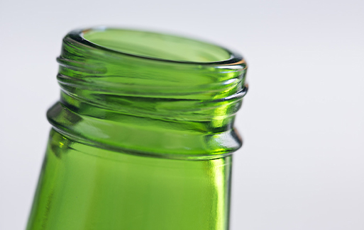 Close up of the top of a green beer bottle