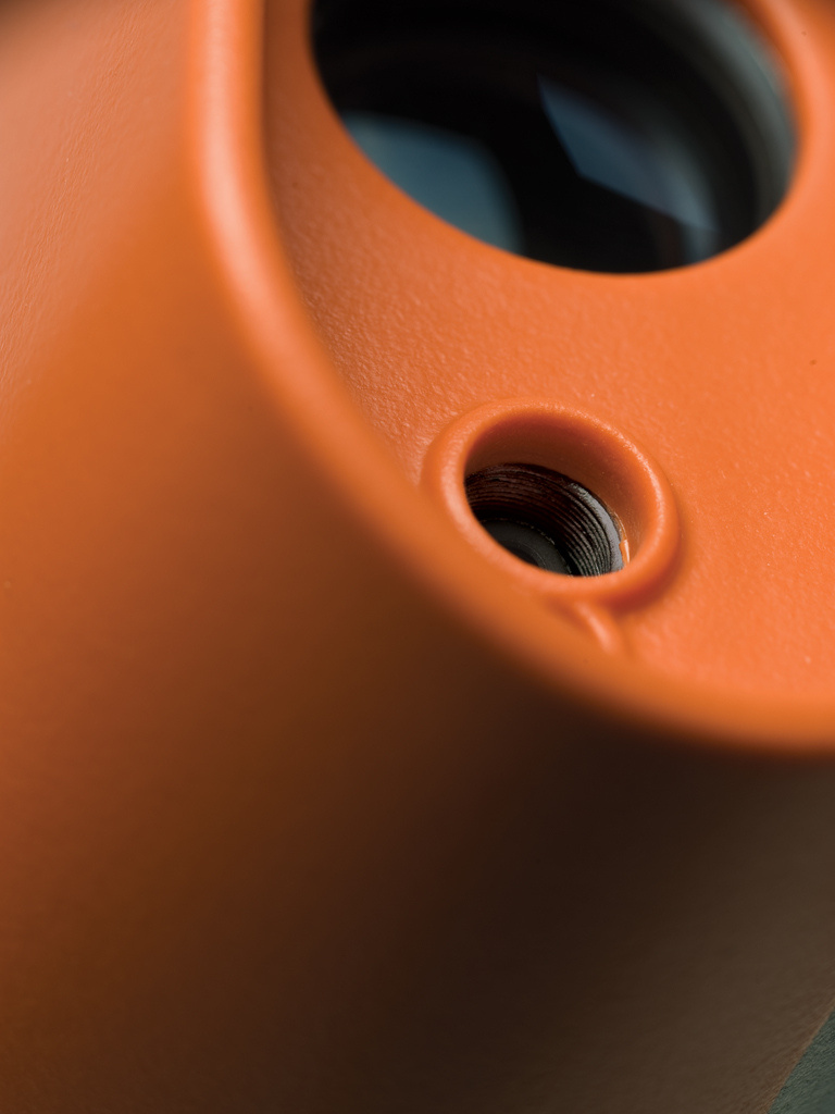 Close up of plastic orange part with round holes