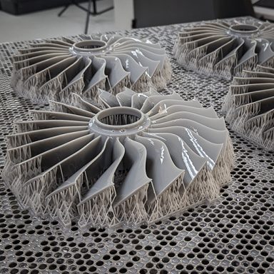 Four 3D Printed Fan Blades in Grey sitting on print bed