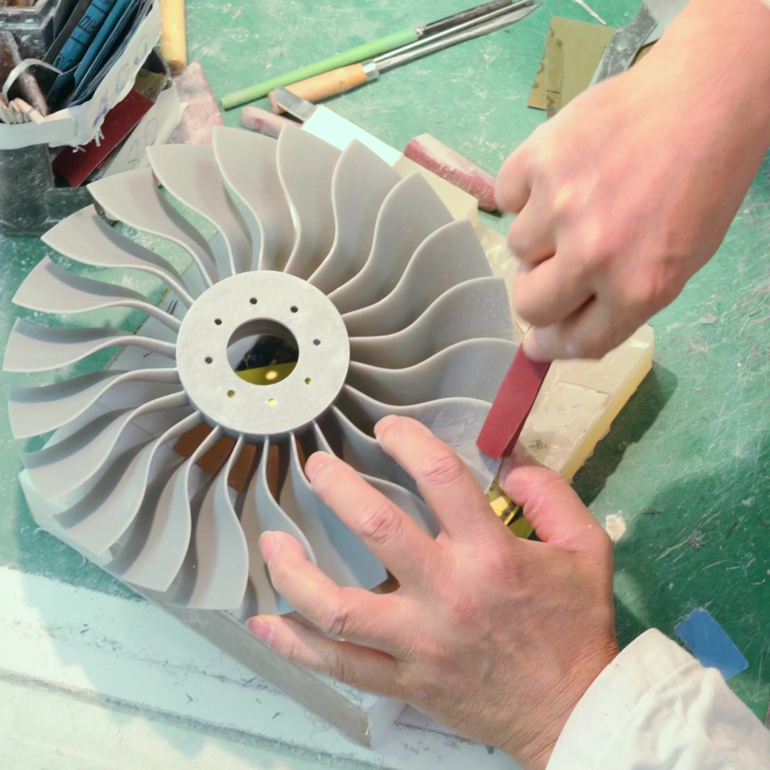 Hands sanding grey fan blade